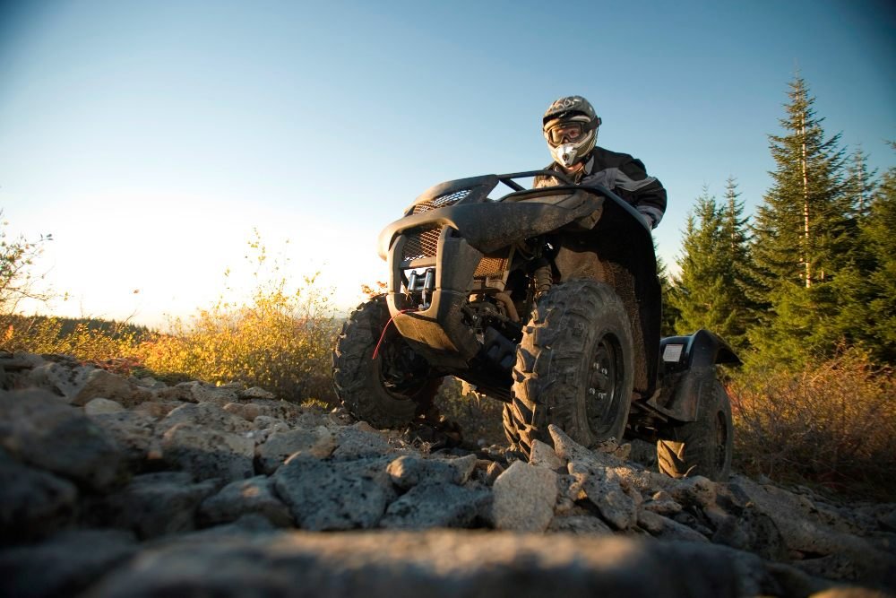 man-riding-atv-up-rocky-hill[1]