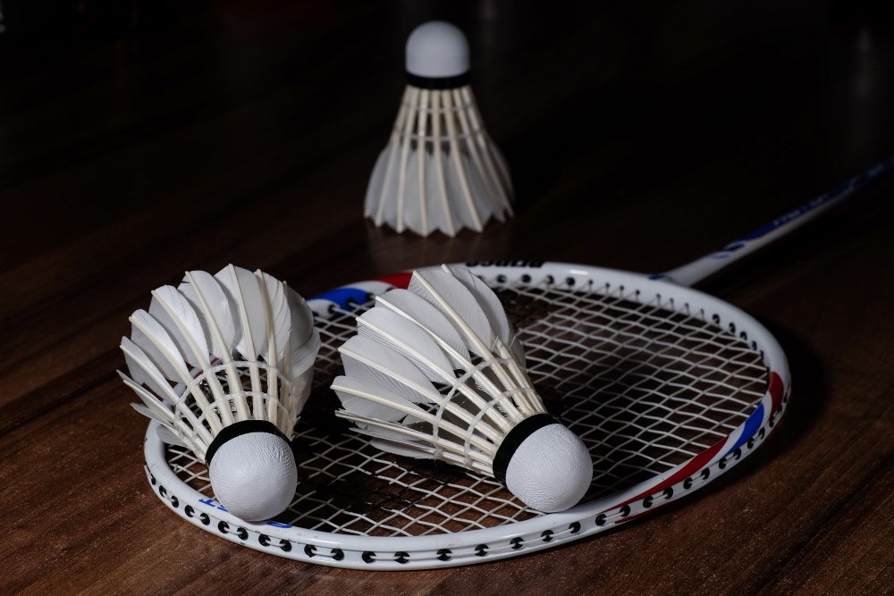 three-white-shuttlecocks-badminton-racquet